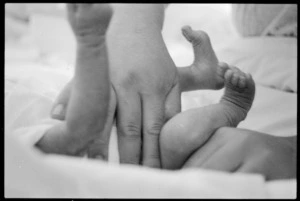 Baby Selina being examined by midwife Joan Skinner, Wainuiomata, New Zealand