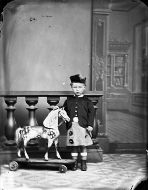 Young boy of the Low family next to a toy horse