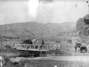 Footbridge and Oldsmobile car alongside a creek between Paraparaumu and Waikanae