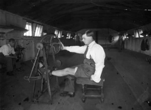 Man (undergoing physiotherapy?) with his foot and and lower leg strapped to a treddle machine