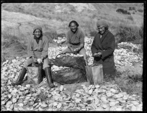 Three Maori girls shelling toheroa on a beach