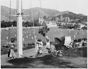 Children playing beside a pram, Basin Reserve, Wellington