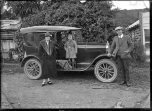 Man, woman and boy, alongside a Model T Ford