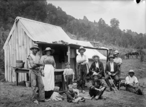 Unidentified group alongside a dwelling in Ohura