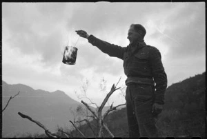 New Zealand soldier fanning a brazier of charcoal, Cassino area, Italy, during World War 2