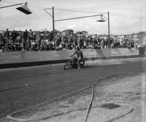 Crowd watching a motorcyclist on the speedway at Kilbirnie Stadium