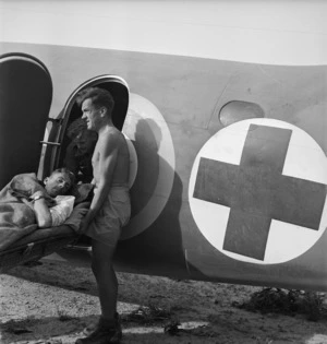 Paton, H fl 1942 : Wounded New Zealand soldier being transferred to an ambulance plane, Tunisia, North Africa