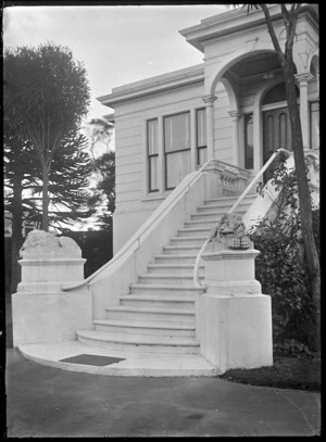 Grand entrance stairway leading to a front door, flanked with two lions on plinths, at a private house in Dunedin.