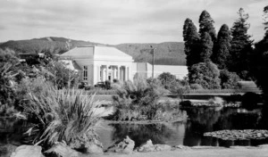 Scene at Rotorua, looking over a pond, towards the Ward Baths