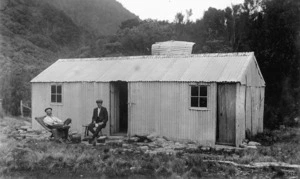 Isaac Jeffares and John Cameron outside a corrugated iron hut