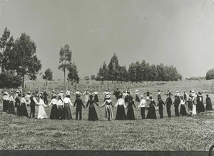 Men and women in a Wairarapa field, playing Drop the Handkerchief - Photographer unidentified