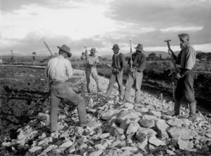 Men breaking up rocks for road construction