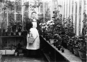 Woman in a glasshouse at the residence of Louis P Christeson at 213 Willis Street, Wellington