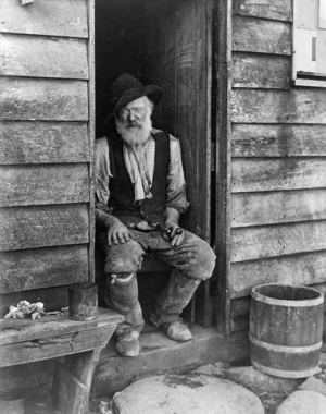 Elderly gold miner outside his hut at Kirwans, West Coast Region