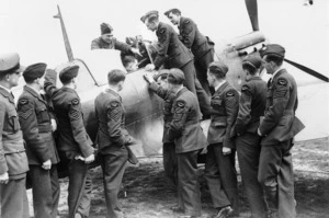 Members of the Royal New Zealand Air Force inspecting a Spitfire aeroplane, Canada