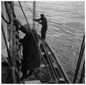 Climbing from surf boats onto a ship