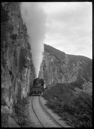 Climax steam locomotive, number 1650, hauling empty logging wagons near Ongarue
