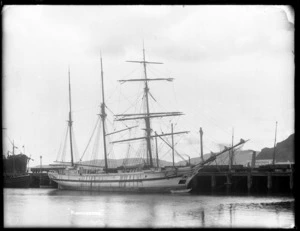 The sailing ship Kongsbyrd at Port Chalmers, with empty railway trucks visible on the wharf behind.
