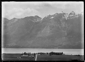 View of Glenorchy on the banks of Lake Wakatipu, with mountain range on the far side of the water.