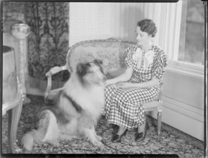Jean Sutherland seated with collie, inside, Homewood, Karori, Wellington