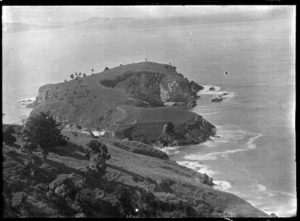 View of unidentified coastline with a promontory jutting out into the sea.