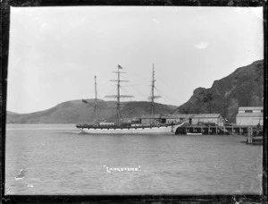 The sailing ship Langstone berthed at Port Chalmers alongside the building of the Shaw Savill & Albion Co. Export Stores.