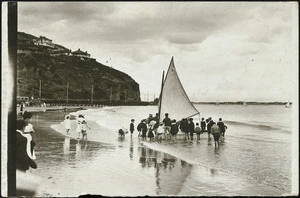 Beach scene, Sumner, Christchurch, showing a group around a yacht