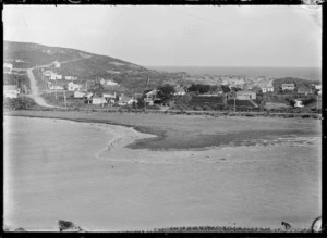 View of an unidentified settlement on a spur of land, with beach in front, and sea beyond.