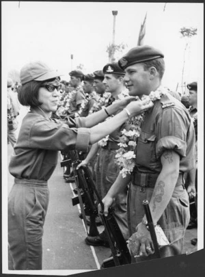 New Zealand soldier presented with a garland of flowers by a woman from the Vietnamese Army, Saigon, Vietnam - Photograph taken by Associated Press