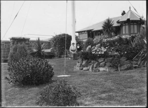 Two women sitting on bench in front of house