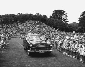 Queen Elizabeth the Queen Mother waves from an open car at a civic reception in Pukekura Park, New Plymouth