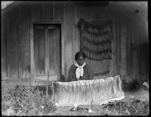 Maori woman weaving a korowai (tag cloak)