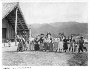 Maori men, women, and children, performing a haka at Mataatua