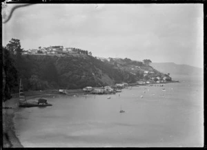 Bay near Port Chalmers, with boatsheds on the waterfront and small boats moored off-shore