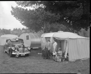 A family in front of their caravan, Taupo Motor Camp