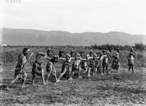 Row of men in semi-traditional Maori clothing, at Kaiwhaiki