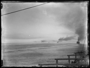 Troopship convoy at steam on the open sea, with troops sitting on deck