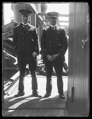 Two unidentified naval officers in uniform on board ship
