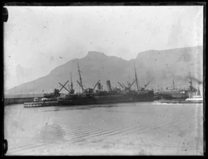 Troopships docked at Cape Town wharf with Lion's head in the background