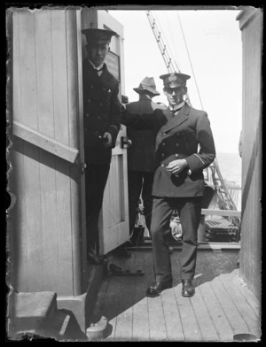 Two unidentified naval officers in uniform on board ship by wireless room