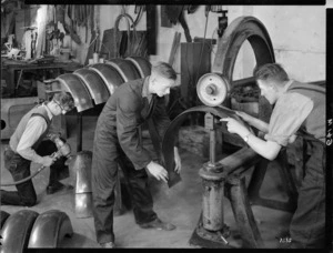 Workers at Standard Motors rolling metal for Army truck mudguards