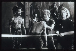 Stunt coordinator Robert Bruce working on fight scene with Toa gang members while camera focal length is measured on the set of Once were warriors, Auckland
