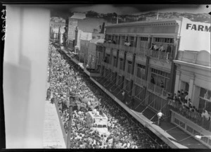 Crowds watching Cuba Street parade, Wellington, including elephants, outside Farmers and Woolworths buildings