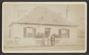 Photographer unknown :Photograph of two ladies and two children standing at gate in front of a dwelling house