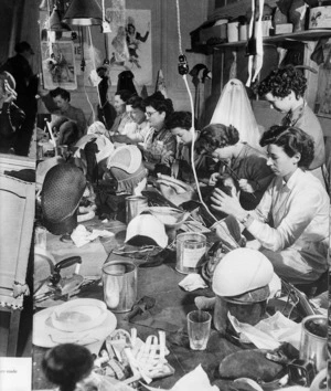 Women sitting around a work table making hats