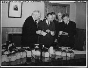 Peter Fraser and the Minister of Supply, with wheat research experts, inspecting loaves of bread