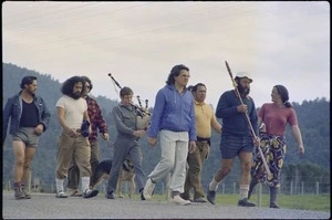 Marchers on the road, including a Highland piper