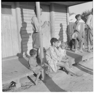 Maori children outside a house, Maori girl with her doll