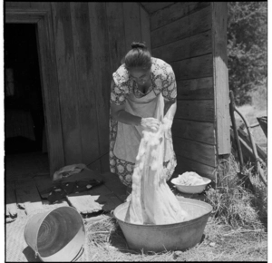 Young boys, Maori woman washing clothes, at a Pentecostal mission hui, Koriniti