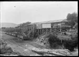 Coal being loaded into railway wagons through chutes, at Saddle Hill, Dunedin.